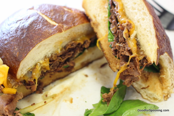 Sliced roast beef on a pretzel roll, grain mustard aoili, caramelized onion marmalade, spinach, and Colby Jack cheese served hot.