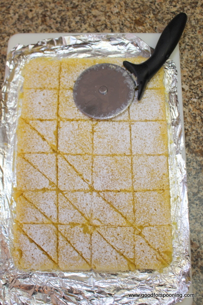 Cut into squares and then diagonally across each to make triangles. I use a moist pizza cutter to glide through.
